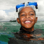 Menino realizando mergulho durante educação ambiental pela promar